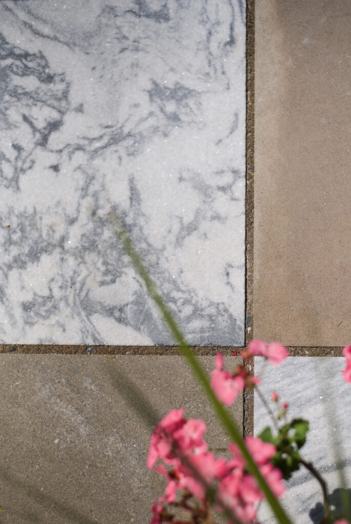 A striking checkerboard patio designed by Jaclyn Isaac using Indiana Limestone and Georgia Marble, forming the centerpiece of her outdoor living space